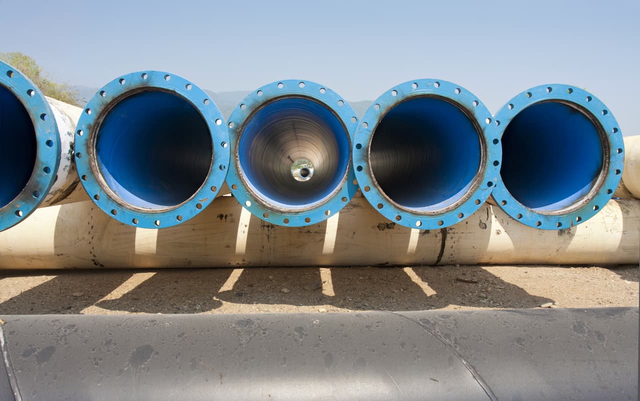 Vista de 3 tubos azules antes de ser colocados para la conducción de agua